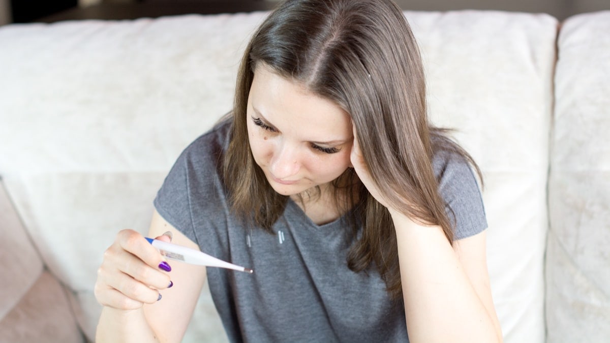 Woman holding thermometer in hands, measuring body temperature. More of my photos and videos Adobe Stock:http://bit.ly/3RqlciK More of my photos and videos Shutterstock: https://www.shutterstock.com/g/ALEKSANDRBERDYUGIN My email: bermix999@gmail.com