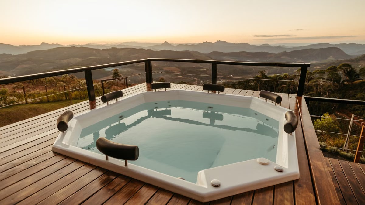 Relaxing hot tub with stunning mountain view at sunset, perfect for luxury retreats.